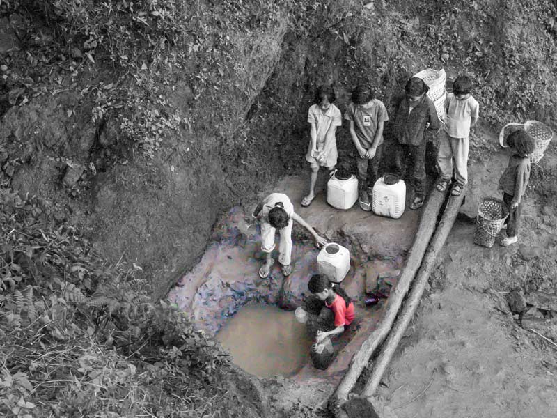 Human Right to Water in Nagaland - Small children procuring water from an unprotected spring-fed pool early in the morning in Tuensang district